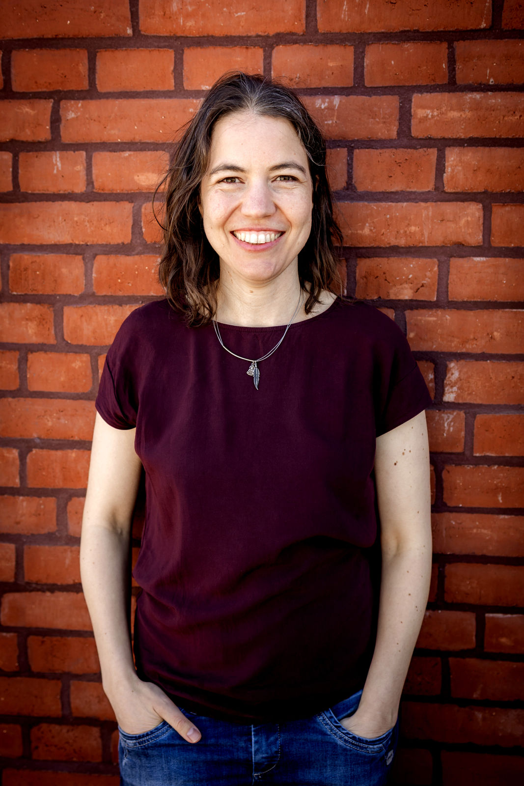 Mareike Klemm, Lehrerin für Alexandertechnik, vor einer Backsteinwand.