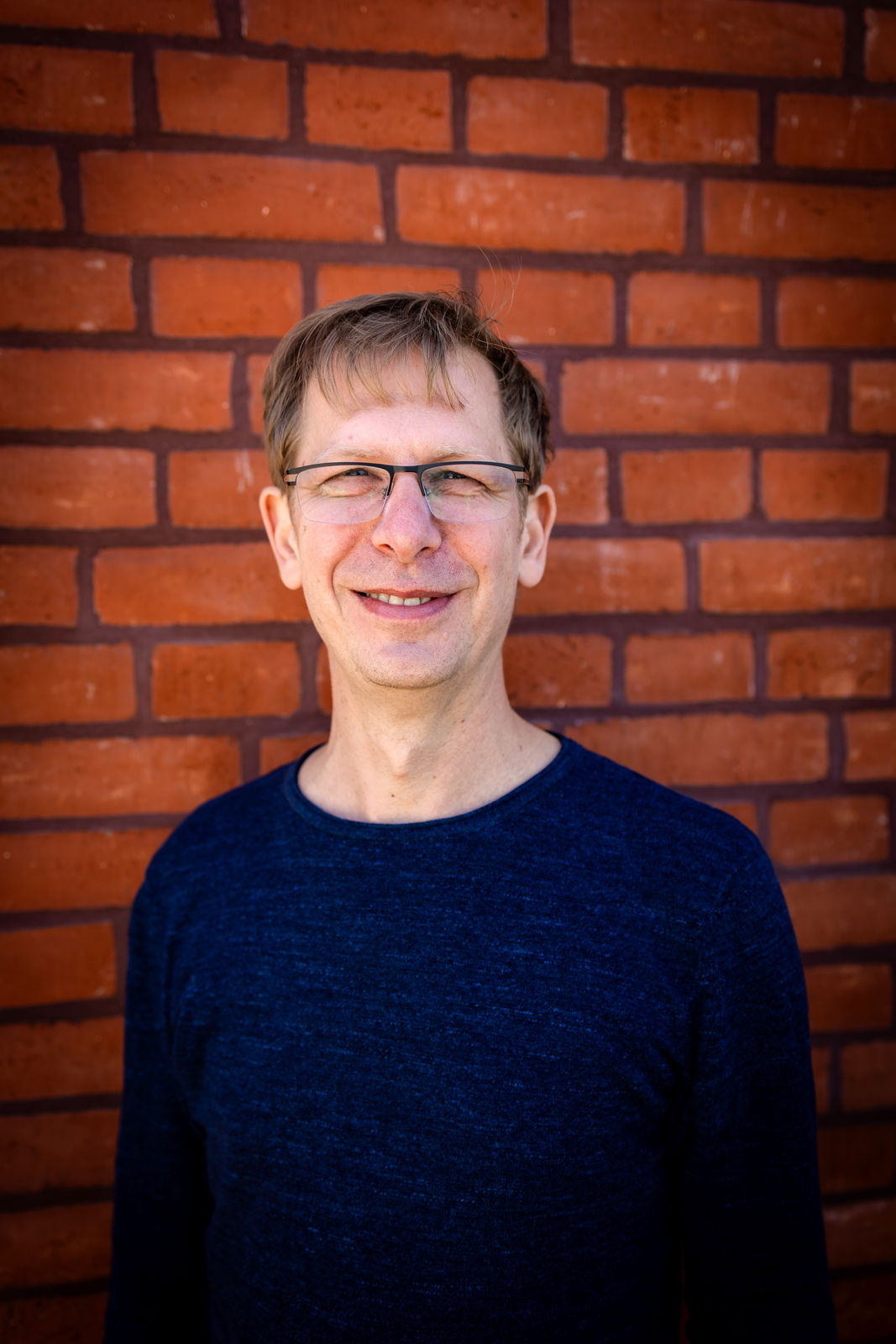 Michael Klemm, Lehrer für Alexandertechnik und Embodiment-Coach, vor einer Backsteinwand.